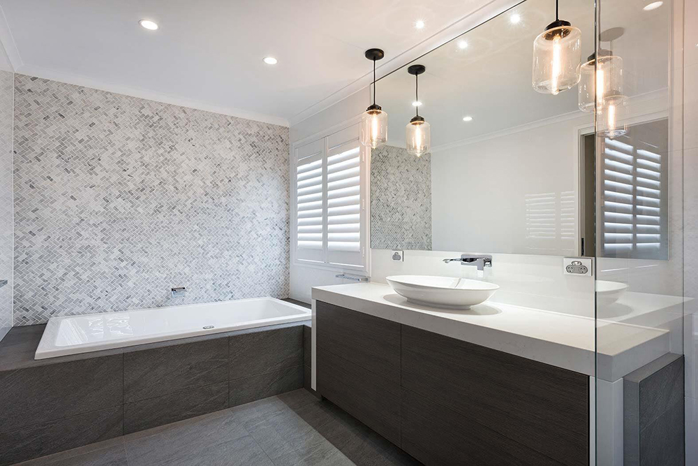 Bathroom with a mosaic tiled feature wall, drop-in bathtub, and pendant lighting
