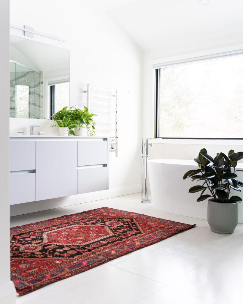 Dark-toned bathroom with pendant lighting, a freestanding bathtub, and floating vanity